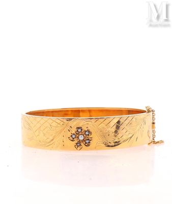 a close up of a gold bracelet on a white background