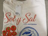 a white t - shirt with a picture of a fish and tomatoes on it