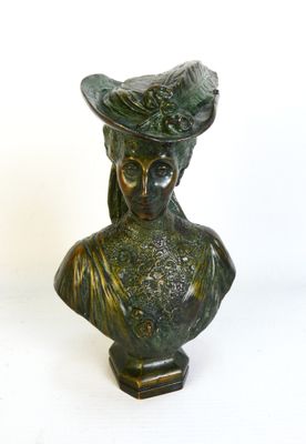un buste en bronze représentant une femme coiffée d'un chapeau