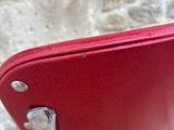 a red chair that is sitting in front of a stone wall