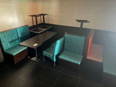 a black table with two green chairs and a black table with a laptop on it