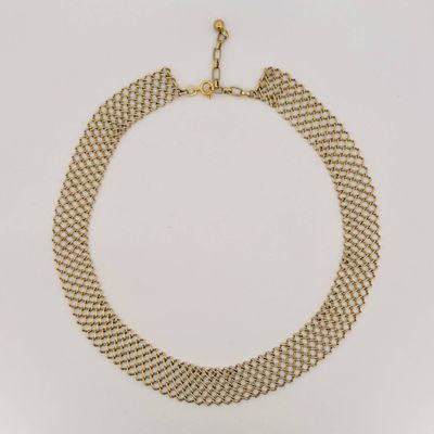 a gold necklace with a chain that has been set on top of it
