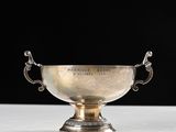 a silver cup on a white table with a black background