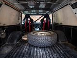 two tires in the back of a truck that is being worked on