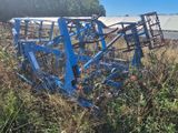 une charrue bleue au milieu d'un champ