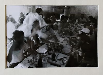 photographie en noir et blanc d'un groupe de personnes assises autour d'une table