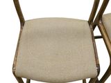 a pair of wooden chairs with beige upholstered seats