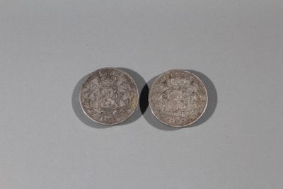 deux pièces d'argent posées l'une sur l'autre sur une surface blanche