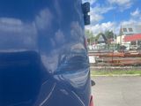 a close up of a blue van parked in a parking lot