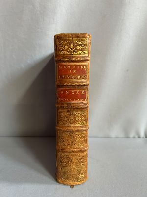 un vieux livre posé sur une table à côté d'un fond blanc