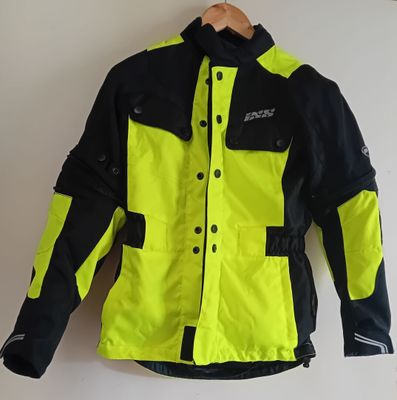 un gros plan sur une veste jaune et noire accrochée à un mur