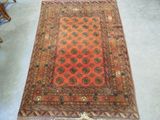 an old rug is on the floor with a chair in the background