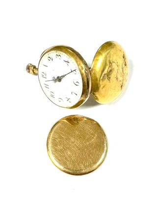 a gold pocket watch sitting next to a gold coin
