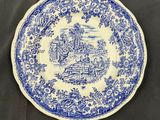 a blue and white plate with a picture of a man riding a horse