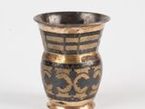 a black and gold vase sitting on a white surface