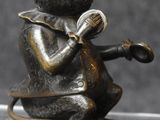 bronze figurine of a mouse playing a musical instrument
