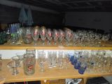 de nombreux verres posés sur une étagère dans une pièce
