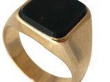 une image d'une bague en or avec une pierre noire au centre