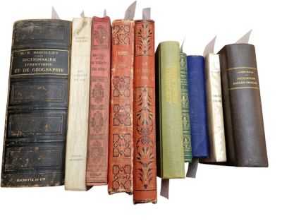 several old books are lined up in a row on a white surface