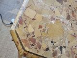 a small table with a marble top on a carpeted floor