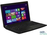 un ordinateur portable posé sur une surface blanche