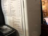 a white refrigerator sitting next to a black trash can