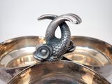 a silver plate with a fish on top of it