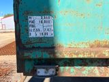 a rusted green dump truck parked on the side of the road