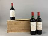 three bottles of wine sit in front of a wooden box