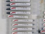 several pens are lined up in a plastic container with labels