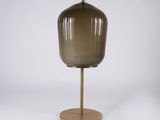 une lampe de table en verre brun posée sur un pied en métal doré