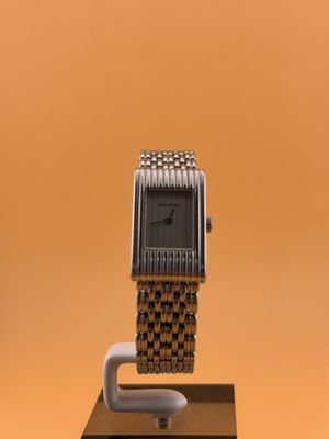 une montre posée sur un socle, sur un fond marron