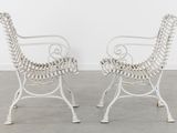 pair of white wrought garden chairs in the style of giraffes