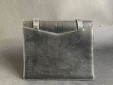 a close up of a silver purse on a gray surface