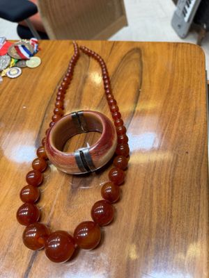 a wooden table with a bracelet and a necklace on it