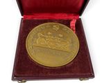 an image of a gold medal in a red box on a white background
