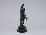 a small bronze statue of a boy holding a bird on a pedestal