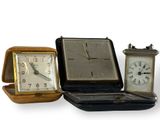 trois horloges différentes posées les unes à côté des autres sur une table
