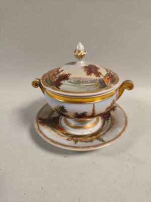 un plateau blanc et doré sur lequel sont posés une tasse et une soucoupe