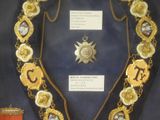 a display case with a necklace and a medal on it