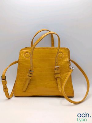 a small yellow handbag with a strap and a shoulder strap