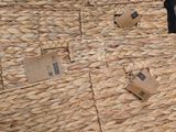a large wicker basket on the ground next to a black umbrella