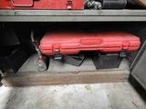 a red tool box sitting on top of a metal shelf