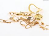 a pile of gold jewelry on a white surface