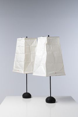 une paire de lampes blanches avec des pieds noirs posées sur une table blanche