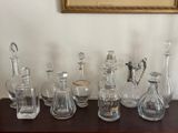 a lot of glass bottles on a table with a picture in the background