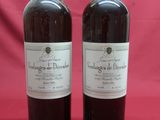 two bottles of wine sitting on top of a red table
