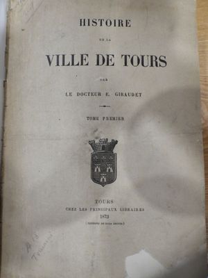 un vieux livre posé sur une table en bois à côté d'une tasse de café