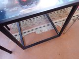 a black table with a glass top on a rug