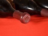 three bottles of wine sitting on a red cloth